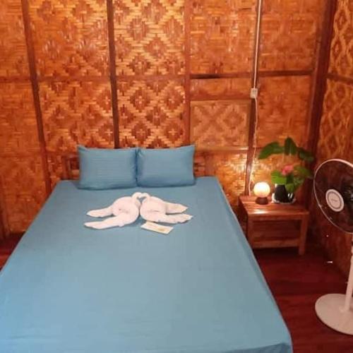 a blue bed with two towels on top of it at SHUKRAN Apartelle in Siquijor