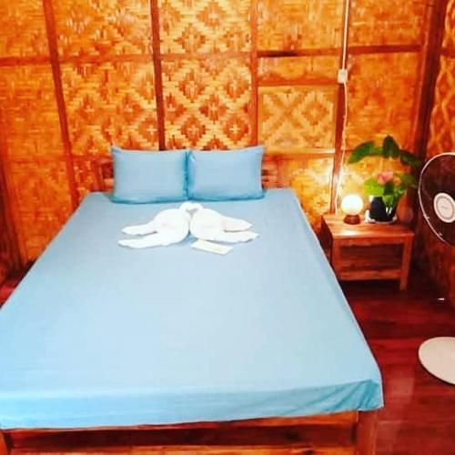 a blue bed with two towels on top of it at SHUKRAN Apartelle in Siquijor