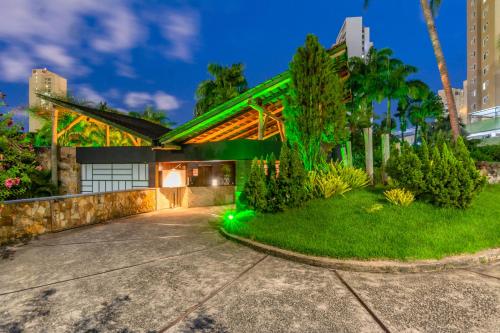 uma casa com luz verde na entrada da garagem em Assahi Motel (Adult Only) em Fortaleza