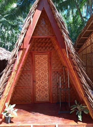 a small building with a thatch roof at SHUKRAN Apartelle in Siquijor