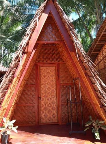 a small wooden house with a thatched roof at SHUKRAN Apartelle in Siquijor