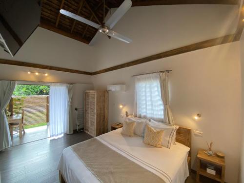 um quarto com uma cama com lençóis brancos e uma janela em Fare noanoa em Mariuti