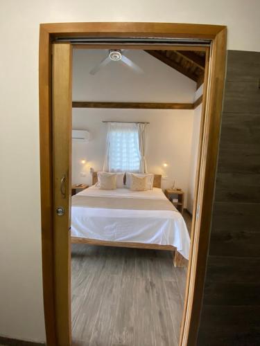 a bedroom with a white bed with a window at Fare noanoa in Mariuti