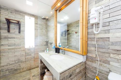 a bathroom with a sink and a mirror at Amagali Pousada in Galinhos