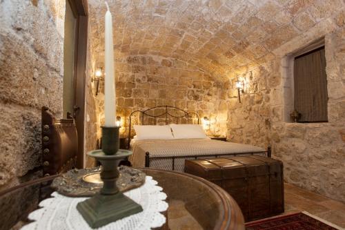 a room with a bed and a table with a candle at Porolithos Boutique Hotel in Rhodes Town
