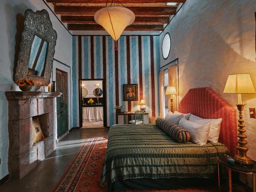 a bedroom with a large bed and a fireplace at Mesón Hidalgo in San Miguel de Allende