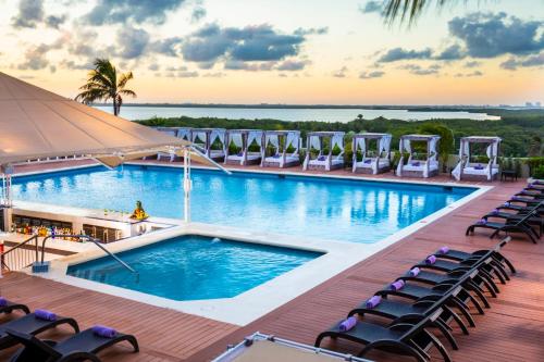 a resort pool with chairs and a view at Crown Paradise Club Cancun - All Inclusive in Cancún