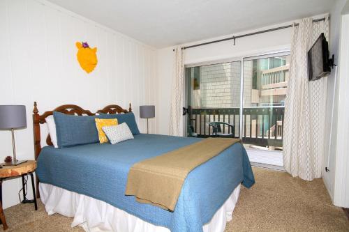 a bedroom with a blue bed and a large window at Sierra Park Villas #04 in Mammoth Lakes