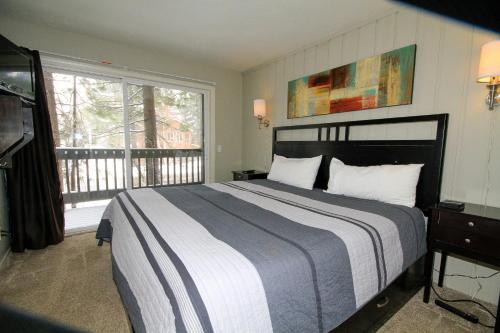 a bedroom with a large bed and a balcony at Sierra Park Villas #03 in Mammoth Lakes