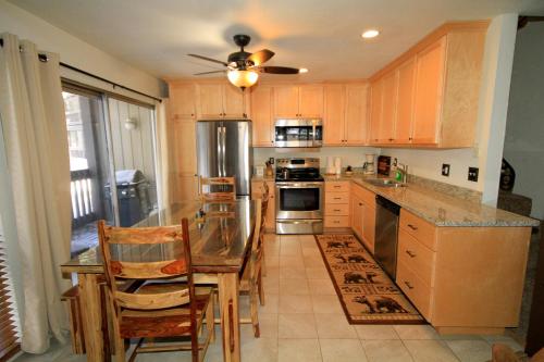 a kitchen with wooden cabinets and a table and chairs at Sierra Park Villas #82 in Mammoth Lakes