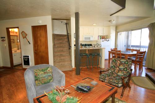 Una sala de estar con mesa y sillas y una cocina. en Sierra Park Villas #16, en Mammoth Lakes