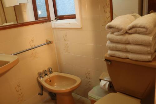 a bathroom with a toilet and a sink and towels at Posada del Parque in Concón