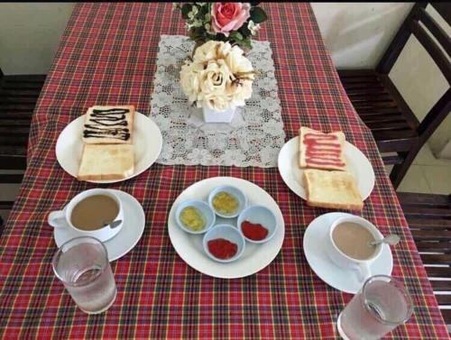a table topped with plates of food and drinks at Polkadot Hostel in Phitsanulok