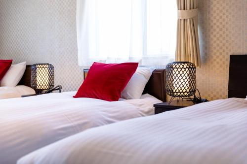 una camera d'albergo con due letti con cuscini rossi di Bon Moment A棟-紅葉館 a Fujikawaguchiko