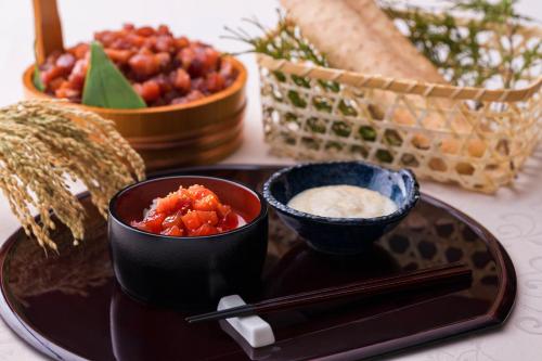 a black plate with two bowls of food on a table at Hotel Metropolitan Kawasaki in Kawasaki