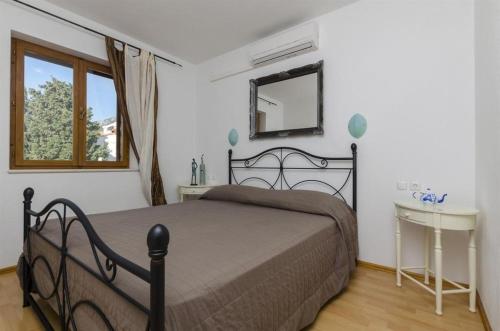 1 dormitorio con cama, espejo y ventana en Apartments Lemar - with parking, en Bol
