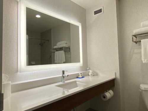 Baño blanco con lavabo y espejo en Holiday Inn Express & Suites Beaumont - Oak Valley, an IHG Hotel en Beaumont