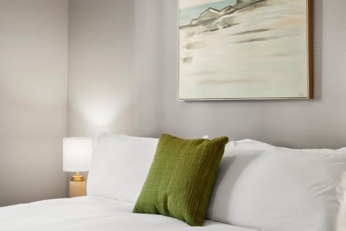 a bedroom with a white bed with a green pillow at Kasa Legacy Town Center Plano in Plano