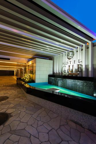 a building with a swimming pool in front of it at Hotel CUE Machida(Adult Only) in Machida