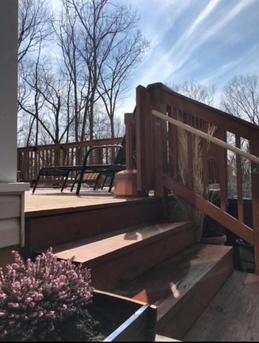 a wooden deck with stairs and benches on it at Pocono cabin with private pool at Shawnee Mtn in East Stroudsburg