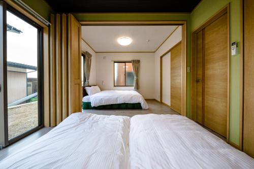 two beds in a room with a window at Furaku-Cat in Fujikawaguchiko