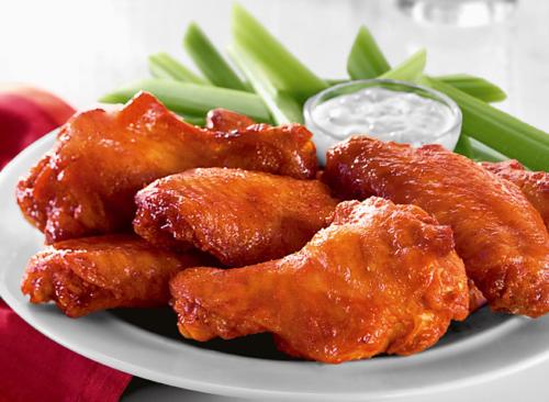 a plate of food with chicken wings and green beans at Holiday Inn Va Beach-Oceanside 21st St by IHG in Virginia Beach
