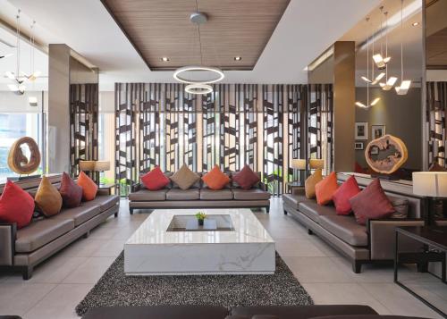 a living room with couches and a table at Altera Hotel and Residence by At Mind in Pattaya Central