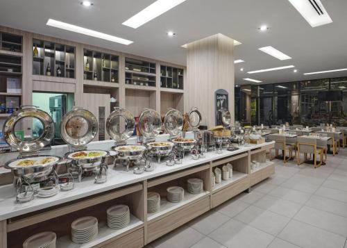 a buffet line with plates and bowls on display at Altera Hotel and Residence by At Mind in Pattaya Central