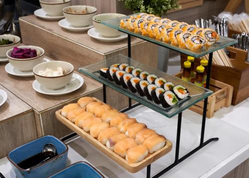a buffet with several trays of sushi and pastries at Altera Hotel and Residence by At Mind in Pattaya Central