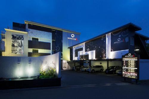 a building with cars parked in a parking lot at Hotel Eldia Machida -Adult Only in Kami-seya