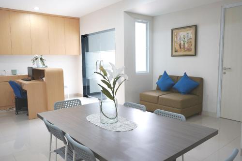 Un comedor y una sala de estar con mesa y sillas. en UROOMS Senayan, en Yakarta