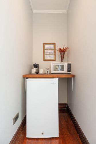 a white refrigerator in a room with a microwave at Posada el Quijote in San José