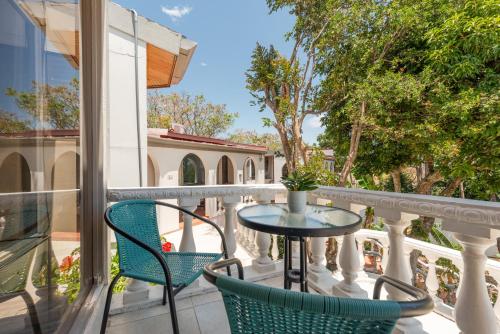 a balcony with two chairs and a table at Posada el Quijote in San José