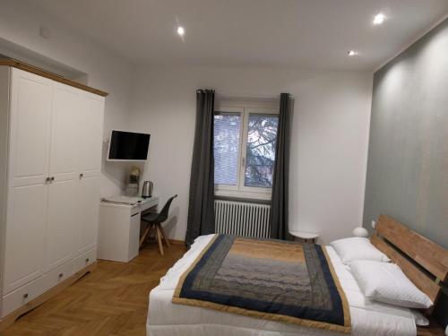 a bedroom with a bed and a desk and a window at "La Selvetta" bed and breakfast in Buguggiate
