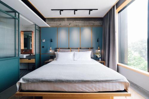 a bedroom with a large bed with a blue wall at KLoe Hotel in Kuala Lumpur