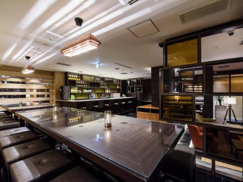 a dining room with a long table and benches at Meguroholic Hotel in Tokyo