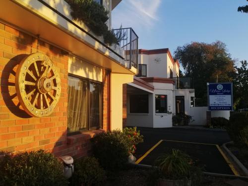 a building with a clock on the side of it at Ulster Lodge Motel in Hamilton