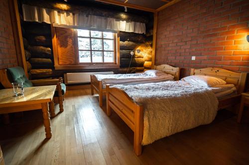 サーリセルカにあるSaarikejo Huskylodgeのレンガの壁、ベッド2台が備わるベッドルーム1室が備わります。