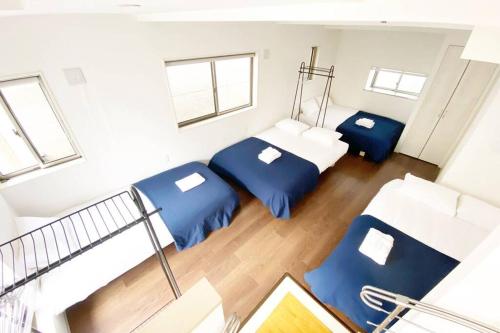 - une petite chambre avec 2 lits et un escalier dans l'établissement SunStay - Tachiaigawa 1, à Tokyo