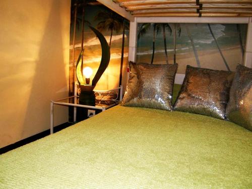 - une chambre avec un lit vert et une lampe sur une table dans l'établissement Cannes Plage, à Cannes