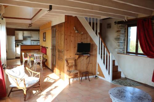 - un salon avec un escalier, une table et des chaises dans l'établissement Les Gîtes Aux Volets Roses, à Landunvez