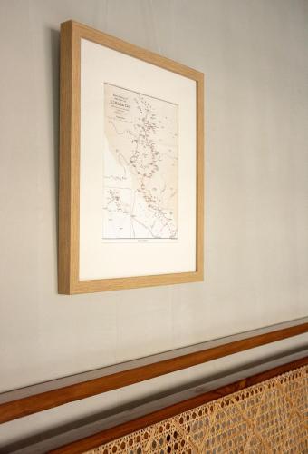 a framed map on a wall above a bench at Amrit Bhawan in Haridwār