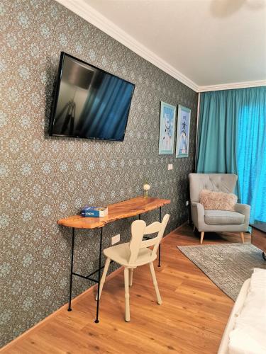 a living room with a table and a television on the wall at Zur Mühle in Bad Birnbach