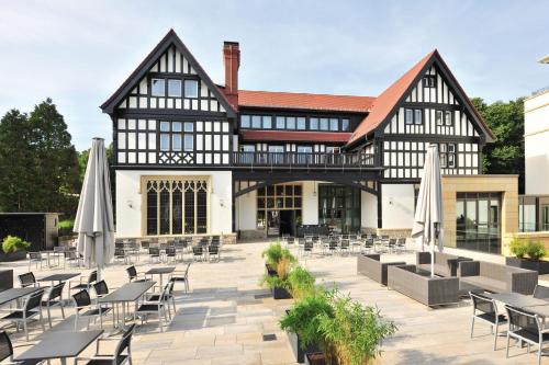 an exterior view of a building with tables and chairs at Dorint Hotel Frankfurt/Oberursel in Oberursel