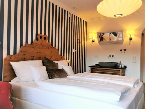 a bedroom with a large white bed with a striped wall at Zur Mühle in Bad Birnbach