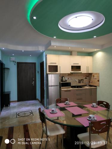 a kitchen with a dining room table with pink tables at Batumi - Orbi Sea Tower & Residence in Batumi