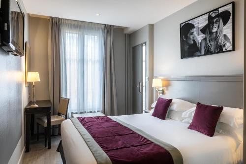 una camera d'albergo con un grande letto e una finestra di Best Western Montcalm a Parigi