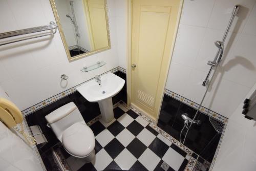 uma casa de banho com um WC, um lavatório e um chuveiro em Migo Hotel em Taichung