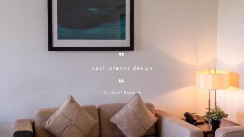 a living room with a couch and a picture on the wall at Lily Hotel Bangkok in Bangkok