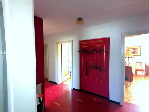 a red door in a room with a dining room at Dimai House 1970s in Hohenems
